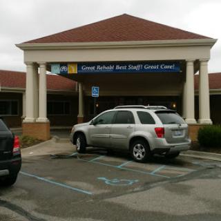 A view of a medical center with parked cars in a cloudy environment.