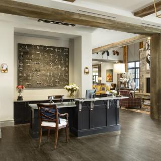 Modern office reception area with industrial design elements and artwork on the wall.
