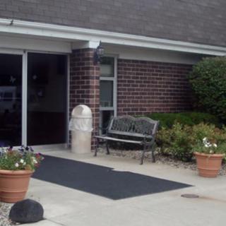 A building entrance featuring a bench and potted plants.