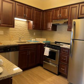 Modern kitchen with stainless steel appliances and wooden cabinets.