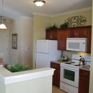 Modern kitchen with white appliances and wooden cabinets.