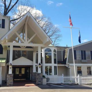 A view of a building entrance with flags and a clear blue sky.