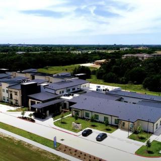 Aerial view of a modern residential building surrounded by greenery.