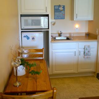 A cozy kitchen and dining area featuring a wooden table, white cabinetry, and modern appliances.