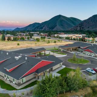 Aerial view of a campus with buildings set against a backdrop of mountains at sunset.