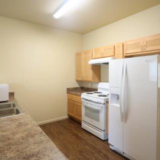 A modern kitchen with wooden cabinets and appliances.