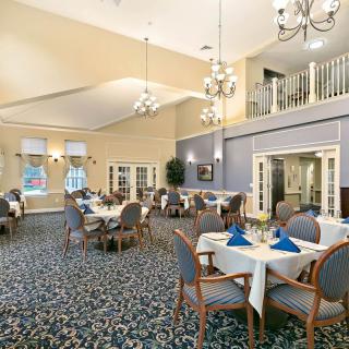 An elegant dining room with neatly arranged tables and chandeliers.