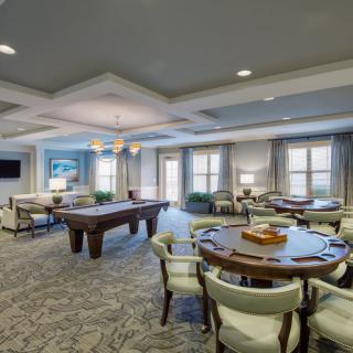A modern lounge area featuring a pool table and comfortable seating.