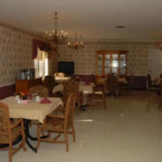 A classic dining room with multiple tables and a chandelier.
