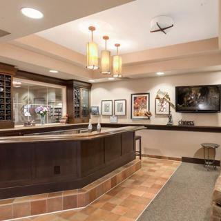 A modern reception area with a wooden counter, artwork, and elegant lighting.