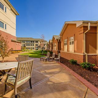 A sunny courtyard with outdoor seating and well-maintained landscaping.