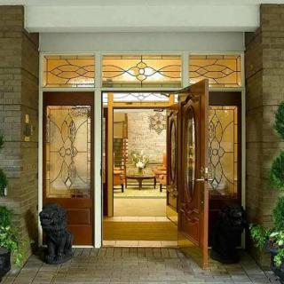 A welcoming entrance with decorative glass doors and potted plants.
