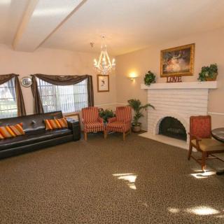 A cozy living room featuring a sofa, two chairs, a fireplace, and elegant decor.