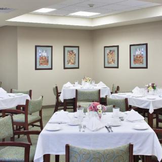 A cozy dining area with tables set for a meal, adorned with white tablecloths and floral centerpieces.