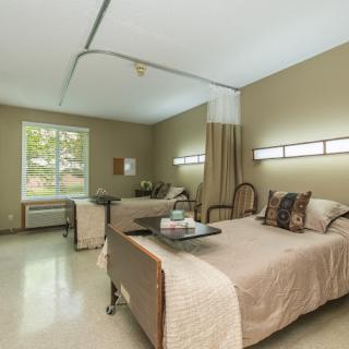 A hospital room with two beds and modern amenities.