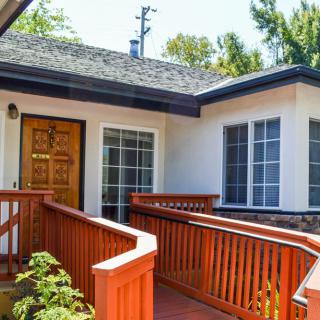 A house entrance with a wooden ramp leading to the front door.