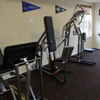 A small gym with various workout machines and exercise equipment.