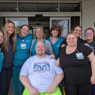 A joyful group of healthcare staff posing together outside, showcasing their camaraderie and dedication.