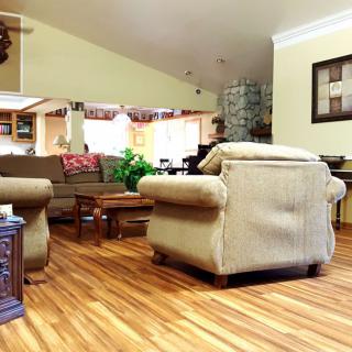 A cozy living room with comfortable armchairs and a sofa, featuring wood flooring and stylish decor.
