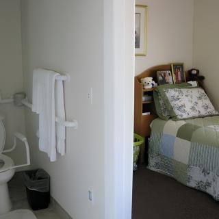 A view of a cozy bedroom with an adjacent bathroom.