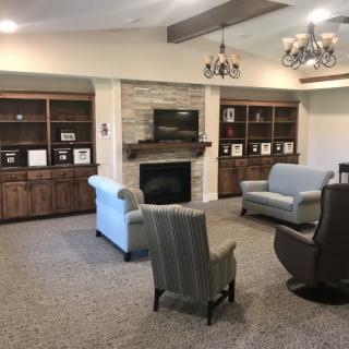 A cozy living room featuring comfortable seating, a fireplace, and built-in shelves.