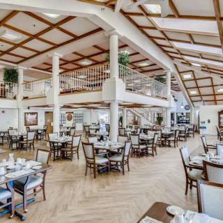 A spacious and elegantly designed restaurant dining area with neatly arranged tables and chairs.