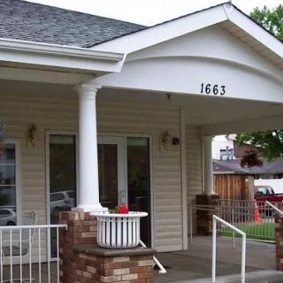 Front view of a house with a porch and columns at the entrance.