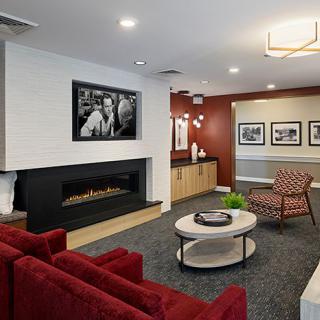 A modern living room with a fireplace, comfortable seating, and stylish artwork on the walls.