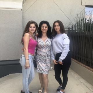 Three women posing for a photo outdoors in casual attire.