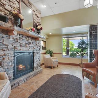 A cozy lounge area featuring a stone fireplace and comfortable seating.