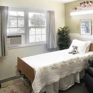 A cozy and minimalist bedroom with a single bed by the window, featuring an air conditioner.