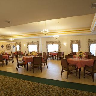 A spacious dining area with neatly arranged tables and elegant chandeliers.