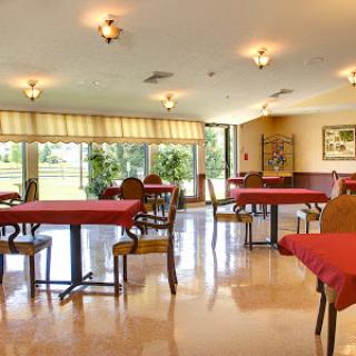 A spacious dining area with red tablecloths and ample natural light.