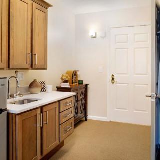 A modern kitchen with wooden cabinets and a white countertop.