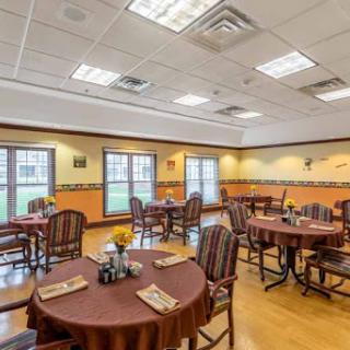 A cozy dining area featuring round tables and wooden chairs, designed for comfortable dining.