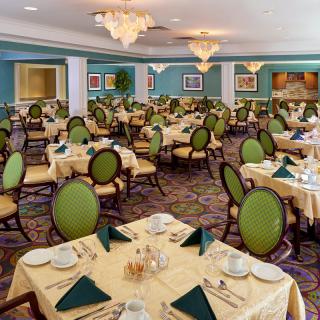 An elegantly decorated dining room with multiple tables set for guests.