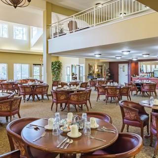A spacious dining room with neatly arranged tables and chairs, ready for guests.