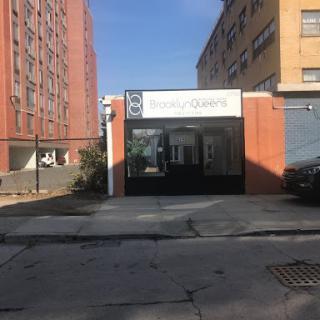 A view of a storefront in an urban area, surrounded by residential buildings.