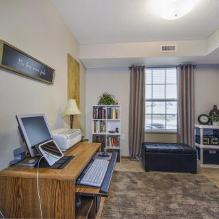 A cozy home office with a desk and computer, neatly organized with a window view.
