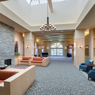 A spacious lobby with comfortable seating and a large chandelier.