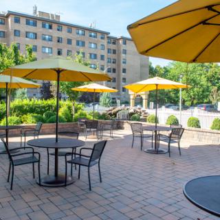 A serene outdoor seating area featuring yellow umbrellas and tables, perfect for enjoying a sunny day.