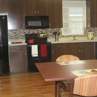 A modern kitchen featuring a dining area with wooden floors and contemporary appliances.