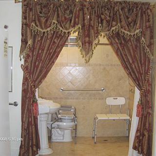 A luxurious bathroom with ornate curtains and a tiled shower area.