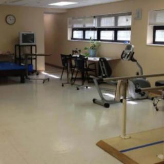 A physical therapy room equipped with parallel bars and exercise equipment.