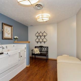 A cozy relaxation room featuring a walk-in tub and seating area with modern decor.
