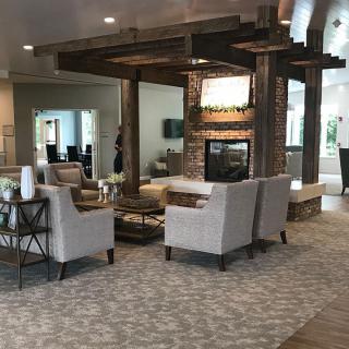 A modern living room with comfortable seating and a central fireplace.