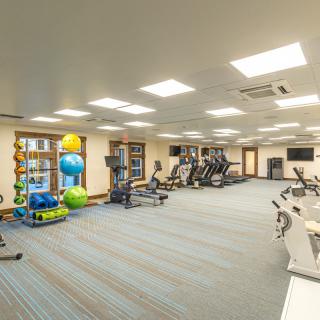 A well-equipped gym with various exercise machines and weights.