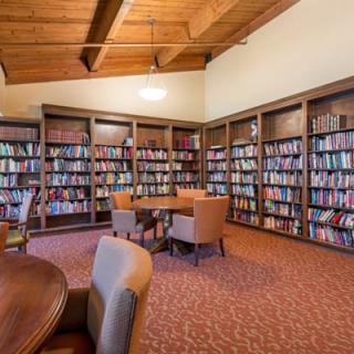 A cozy library reading room with bookshelves and comfortable seating.