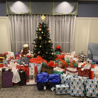 A beautifully decorated Christmas tree surrounded by numerous wrapped presents, ready for a festive celebration.