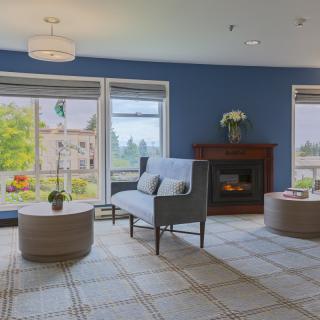 A cozy living room with a fireplace and large windows offering a scenic view.